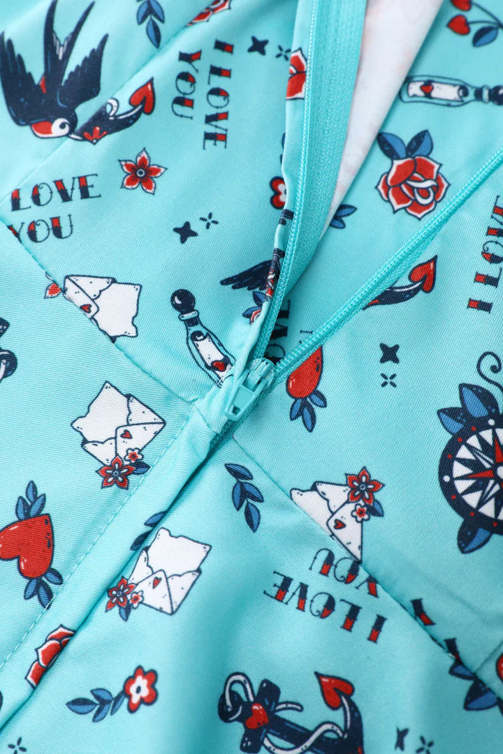 Close-up of a blue fabric with tattoo-style patterns, including birds, hearts, and 'I love you' text.