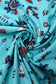 Turquoise fabric with colorful tattoo-style designs, fabric close up