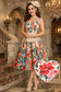 Woman in a floral dress standing in an elegant interior setting with a heart-shaped inset of a floral design.